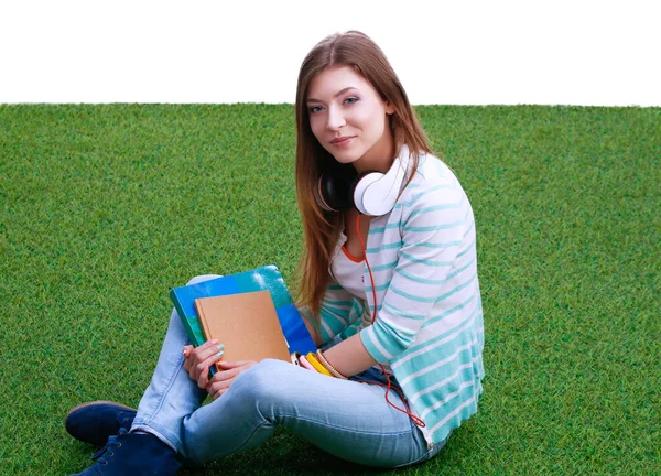 Mooie jonge vrouw zittend op het gras — Stockfoto