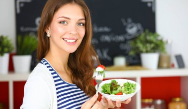 Salata yemek ve karışık salata tutan genç kadın