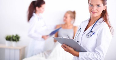 Hastanede üniformalı, gülümseyen bir kadın doktor.