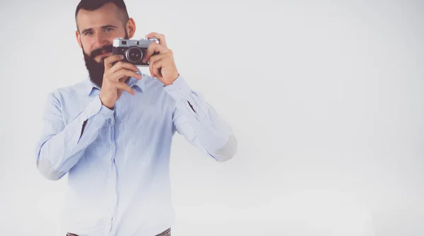 Joven barbudo enfocándose en ti con su cámara mientras está de pie — Foto de Stock