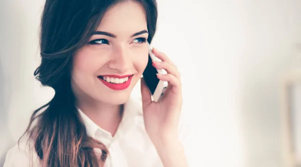 Mulher de negócios sorrindo falando ao telefone sentado no escritório — Fotografia de Stock