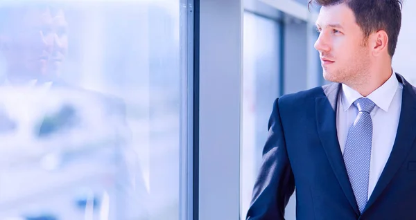 Successful businessman standing in hallway his company near window — Stock Photo, Image