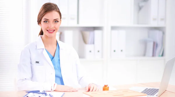 Kobieta lekarz siedzi na biurku i pracuje laptopa w hospi — Zdjęcie stockowe