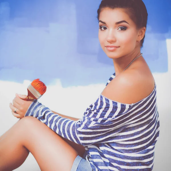 Portrait of female painter sitting on floor near wall after painting. — Stock Photo, Image