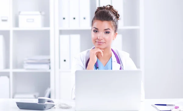Vrouwelijke arts zit op het bureau en werkt een laptop in het ziekenhuis — Stockfoto