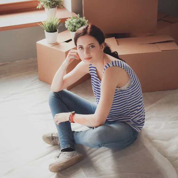 Mujer en un nuevo hogar con cajas de cartón — Foto de Stock