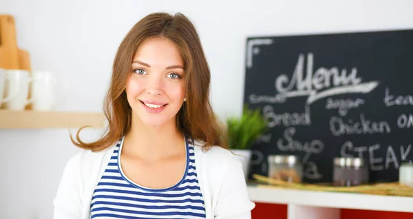 Giovane donna in piedi vicino alla scrivania in cucina — Foto Stock