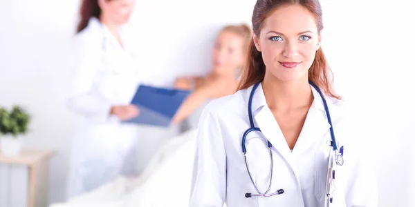 Smiling female doctor with a folder in uniform standing at hospital — Stock Photo, Image