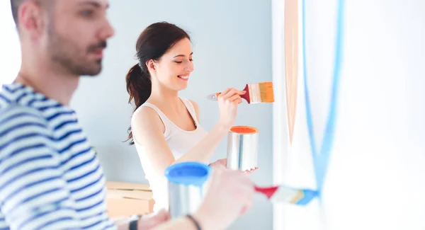 Jovem casal parede de pintura em casa — Fotografia de Stock