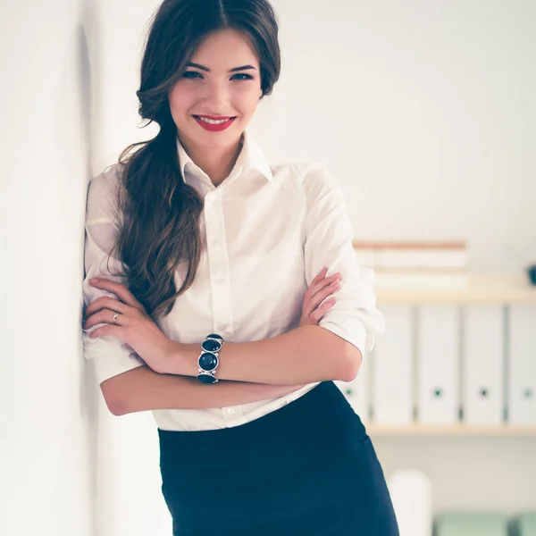 Attractive businesswoman with her arms crossed  standing in off — Stock Photo, Image