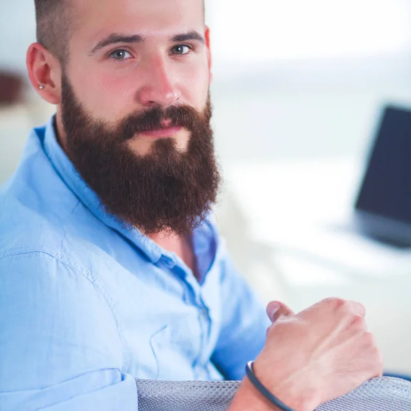 Jonge zakenman zit op stoel in functie — Stockfoto