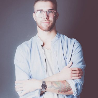 Mutlu bir casual adam ayakta karanlık bir arka plan üzerinde izole portresi