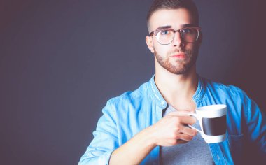 Ayakta ve elinde fincan kahve onun elinde portre yakışıklı genç adam