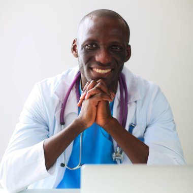 Masada dizüstü bilgisayarda çalışan genç bir Afrikalı doktor.