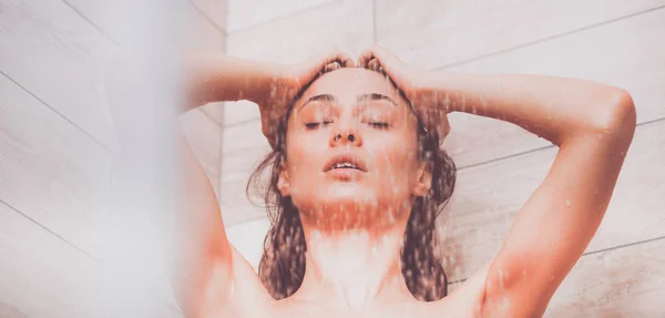 Young beautyful woman under shower in bathroom — Stock Photo, Image