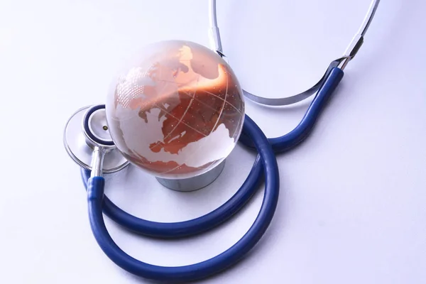 Sanità globale. Globe e stetoscopio, studio shot.blue immagini toniche — Foto Stock