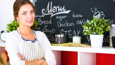 Mutfakta masanın yanında duran genç bir kadın.