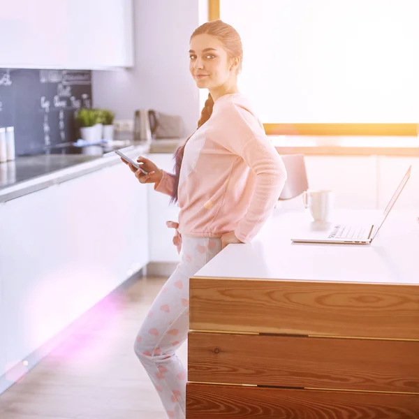 Hermosa mujer cocinando pastel en la cocina de pie cerca del escritorio — Foto de Stock