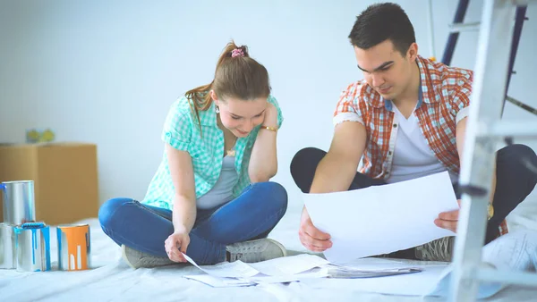 Young couple sitting on floor and calculating about they savings — Stock Photo, Image