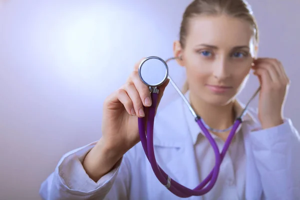 En ung kvinnlig läkare lyssnar, håller medicinsk stetoskop — Stockfoto