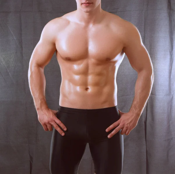 Przystojny mięśni młody człowiek stojący na czarnym tle — Zdjęcie stockowe