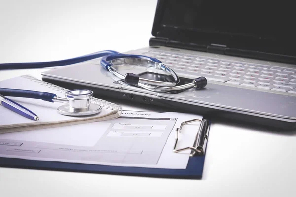 Stethoskop mit Klemmbrett und Laptop auf dem Schreibtisch — Stockfoto