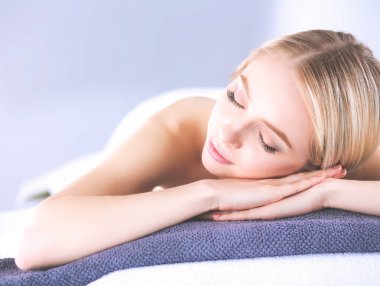 Gözleri kapalı rahatlatıcı bir masaj masanın üzerinde yatan genç kadın