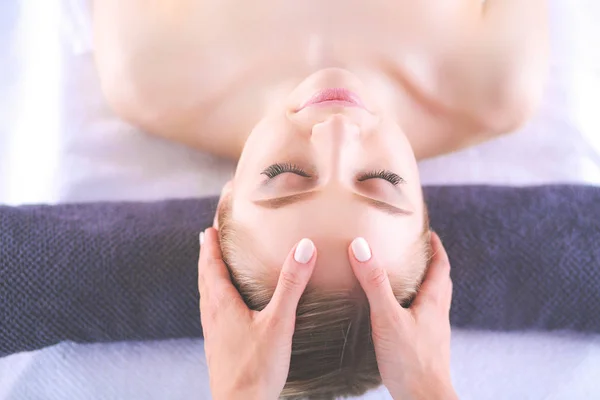 Jonge vrouw liggend op een massagetafel, ontspannen met ogen dicht — Stockfoto