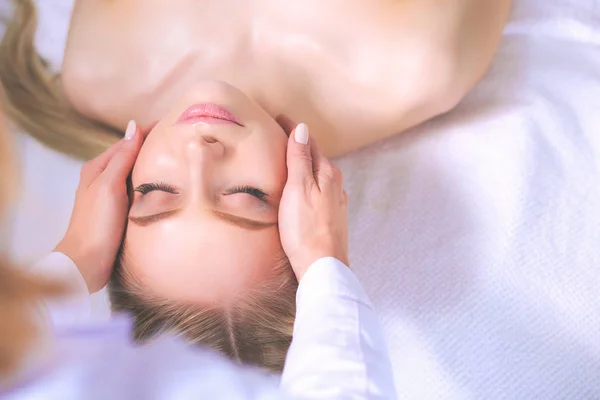 Young woman lying on a massage table,relaxing with eyes closed — Stock Photo, Image