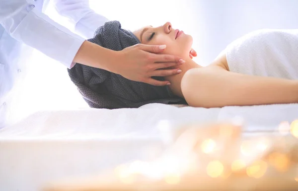 Jonge vrouw liggend op een massagetafel, ontspannen met ogen dicht — Stockfoto