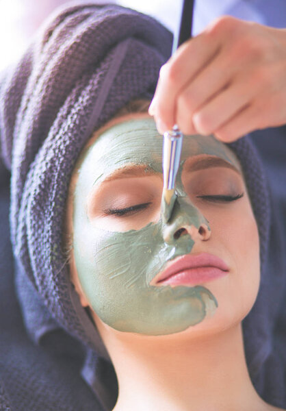 Beautiful woman having mask , lying on spa