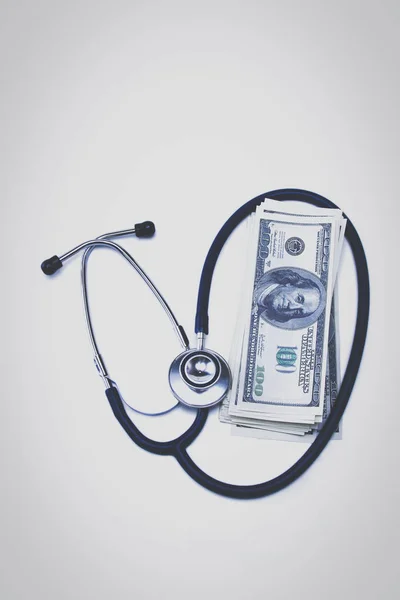 Medical stethoscope and 100 dollar bills on white background — Stock Photo, Image