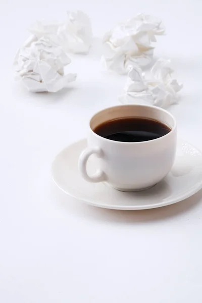 Работа со скомканной бумагой и кофейной чашкой на фоне стола — стоковое фото