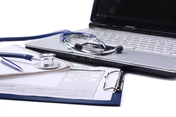 Stéthoscope avec presse-papiers et ordinateur portable sur le bureau — Photo