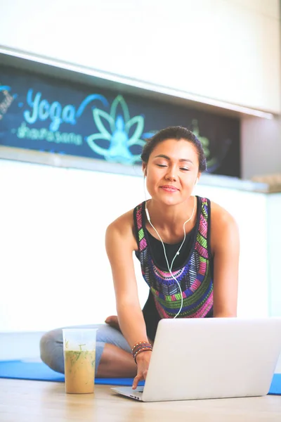 Deportiva mujer sonriente utilizando el ordenador portátil en habitación luminosa — Foto de Stock