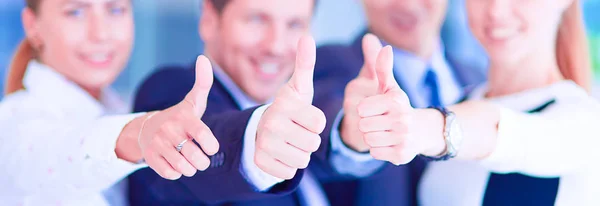 Счастливая бизнес-команда, демонстрирующая большие пальцы в офисе — стоковое фото