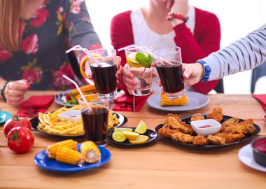 Yemek masasında içki içen insanlar.