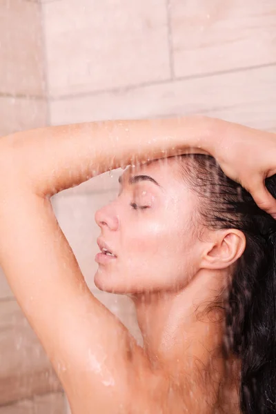 Jeune femme belle sous la douche dans la salle de bain — Photo