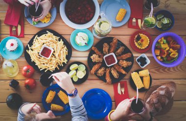 İnsanlar içecekler yemek masasında otururken. Masaya yiyecek. Masaya yiyecek. İnsanlar hızlı yemek yemek.