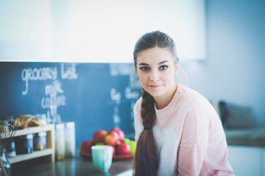 Mutfakta masada oturan genç kadın.