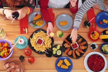 Birlikte yemek yiyen bir grup insanın üst düzey görüntüsü.