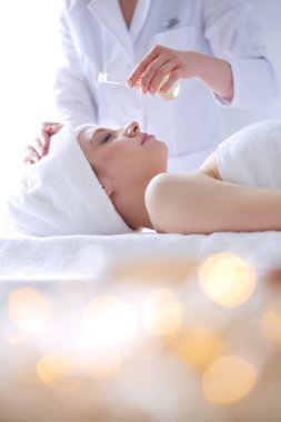 Gözleri kapalı rahatlatıcı bir masaj masanın üzerinde yatan genç kadın.