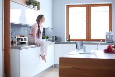 Mutfakta masada oturan genç kadın.