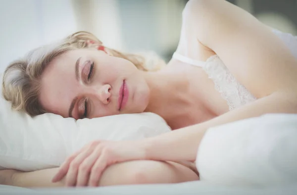 Hübsche Frau legt sich zu Hause auf ihr Bett. — Stockfoto