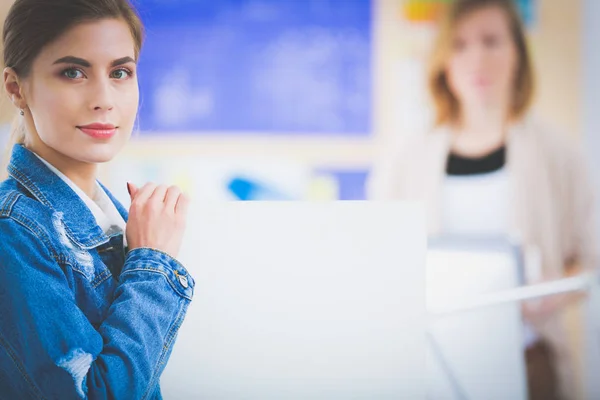 机の近くに楽器と計画とノートパソコンを持った二人の若い女性. — ストック写真