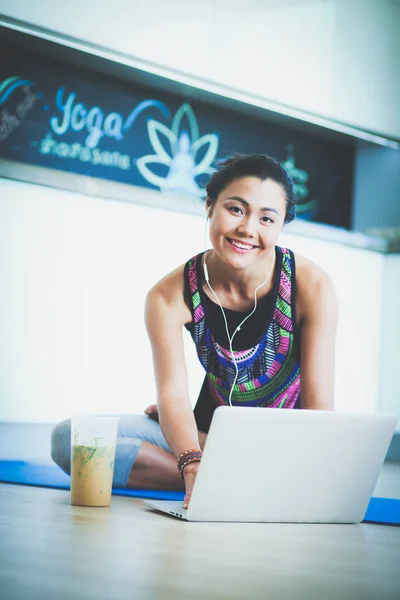 Deportiva mujer sonriente utilizando el ordenador portátil en la habitación luminosa. Una mujer. Estilo de vida — Foto de Stock