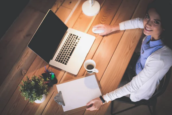 Masasında oturan ve elinde bir fincan kahveyle rahatlamış genç bir kadının portresi. İş kadını. İşyeri