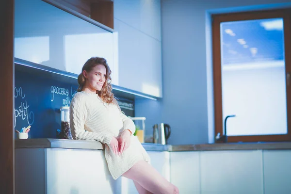 Jovem mulher de pé na cozinha. — Fotografia de Stock