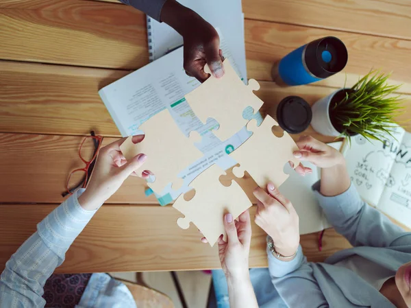 Close-up photo of businesspeople holding jigsaw puzzle. — Stock Photo, Image