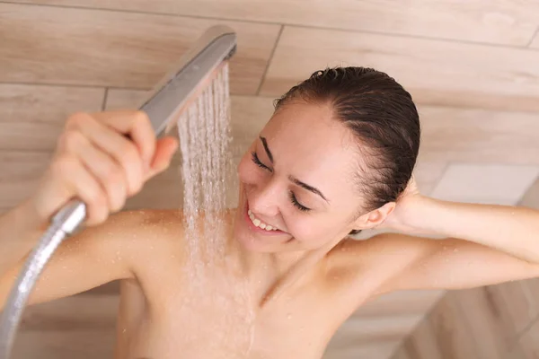 Joven mujer hermosa bajo la ducha en el baño . — Foto de Stock